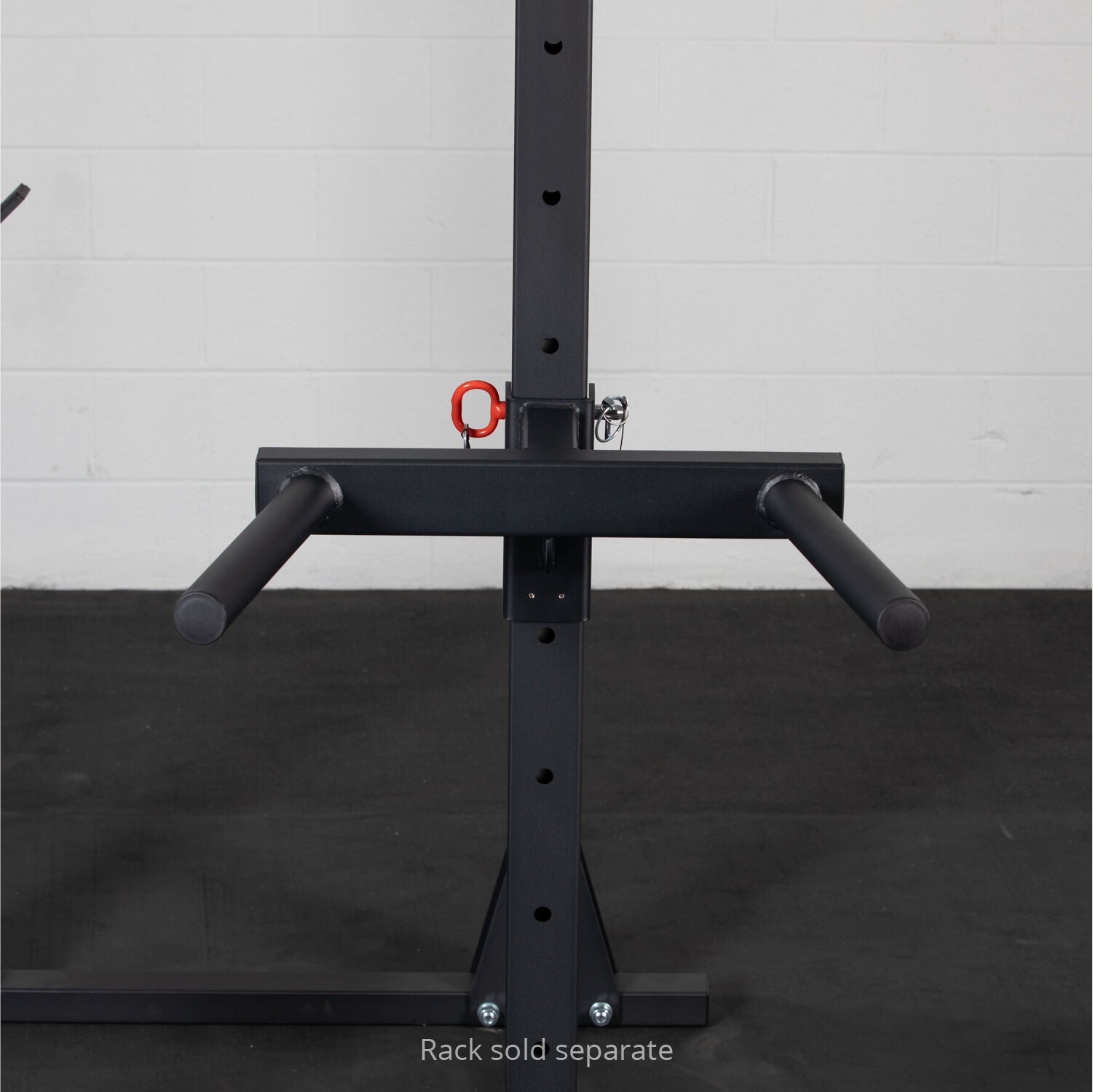 A black, sturdy Titan Fitness X-3 Series Y-Dip attachment with padded grips, highlighting a red lock, is mounted on a vertical post with a noticeable label indicating 'rack sold separately', set against